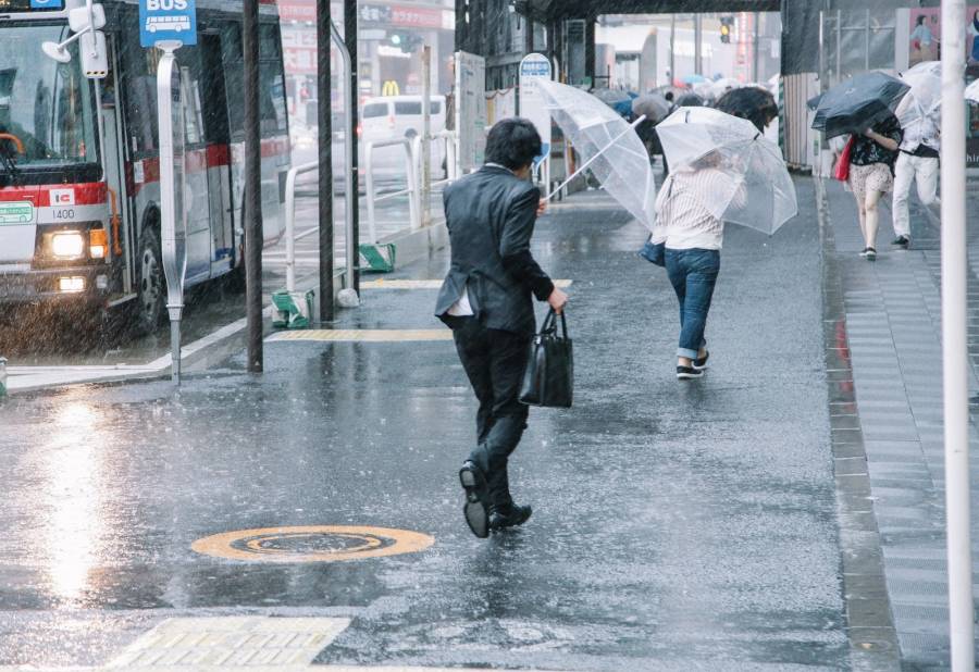 大雨の中濡れている男性