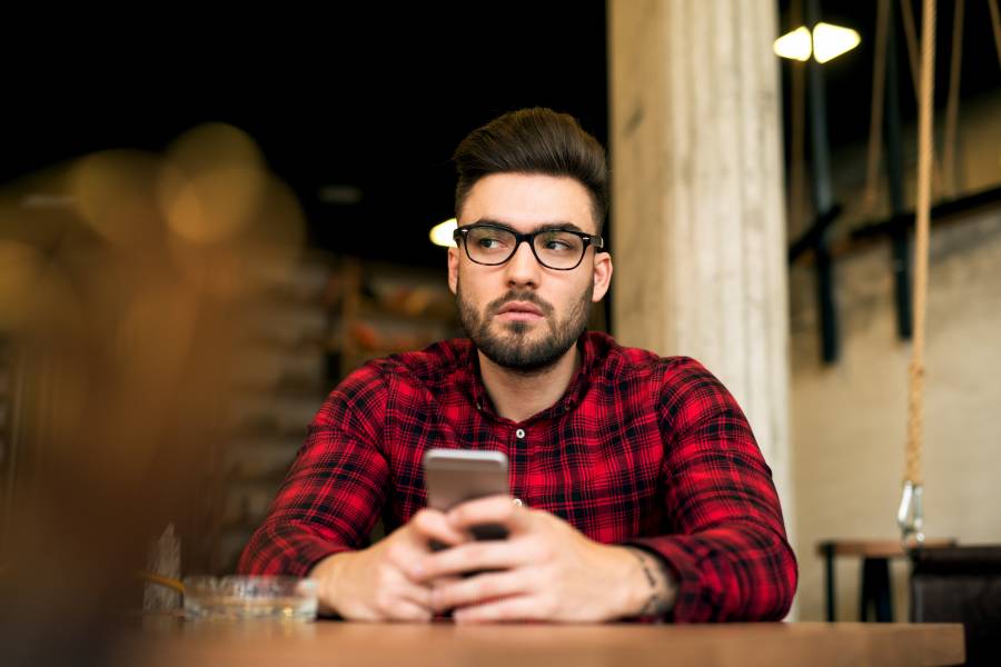 スマホを持ち、ぼうっとする男性。