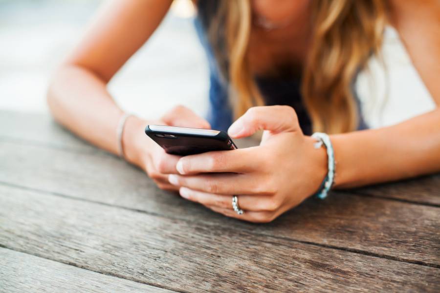 スマホに触れる金髪の女性