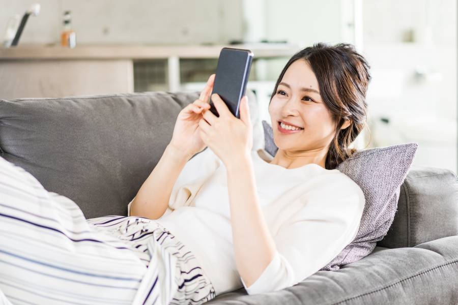 部屋でスマホを使う若い女性