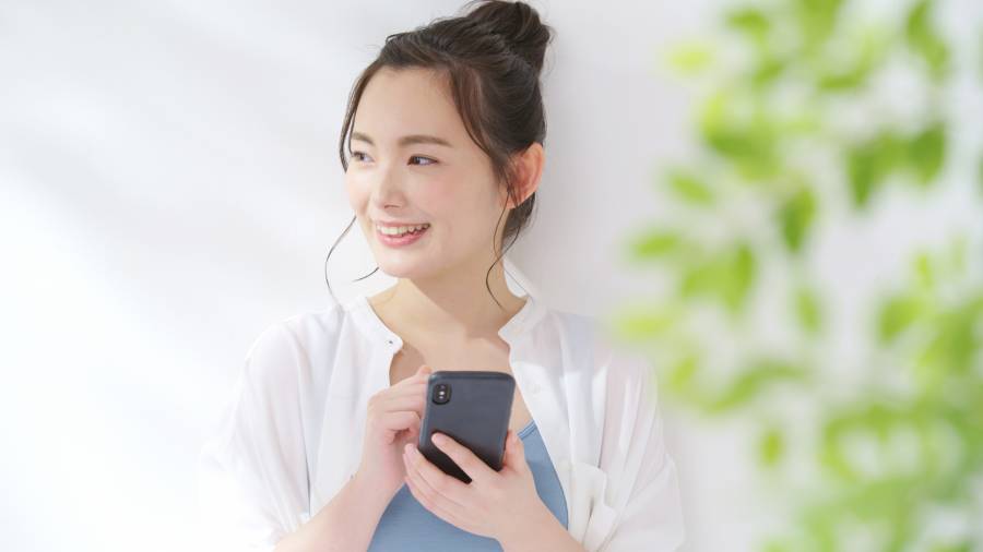 スマホを見て微笑む女性。