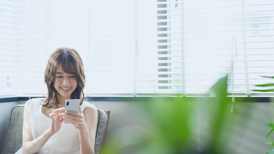 スマホを見て笑顔の女性。