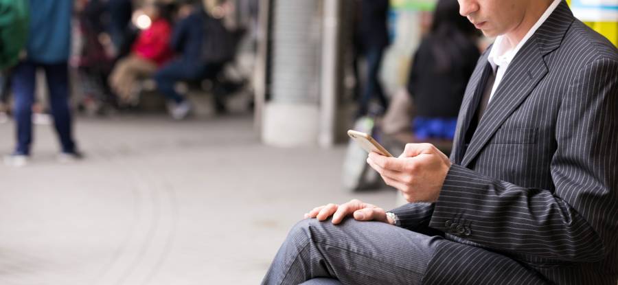 街でスマホに触れる男性