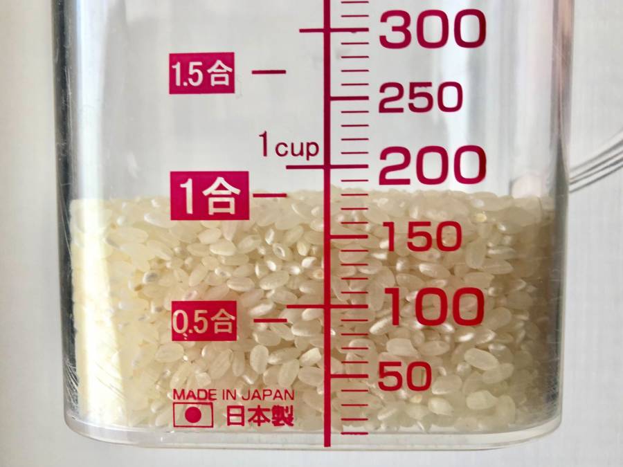 一般的な計量カップで米を量るイメージ