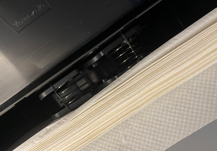 山崎実業towerシリーズ ウォールペーパーホルダーの使用レポート画像。輪ゴムでスプリングを調整したペーパーを押し出すバネを設置している様子