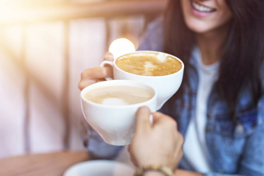 カフェでカップを持つ女性。